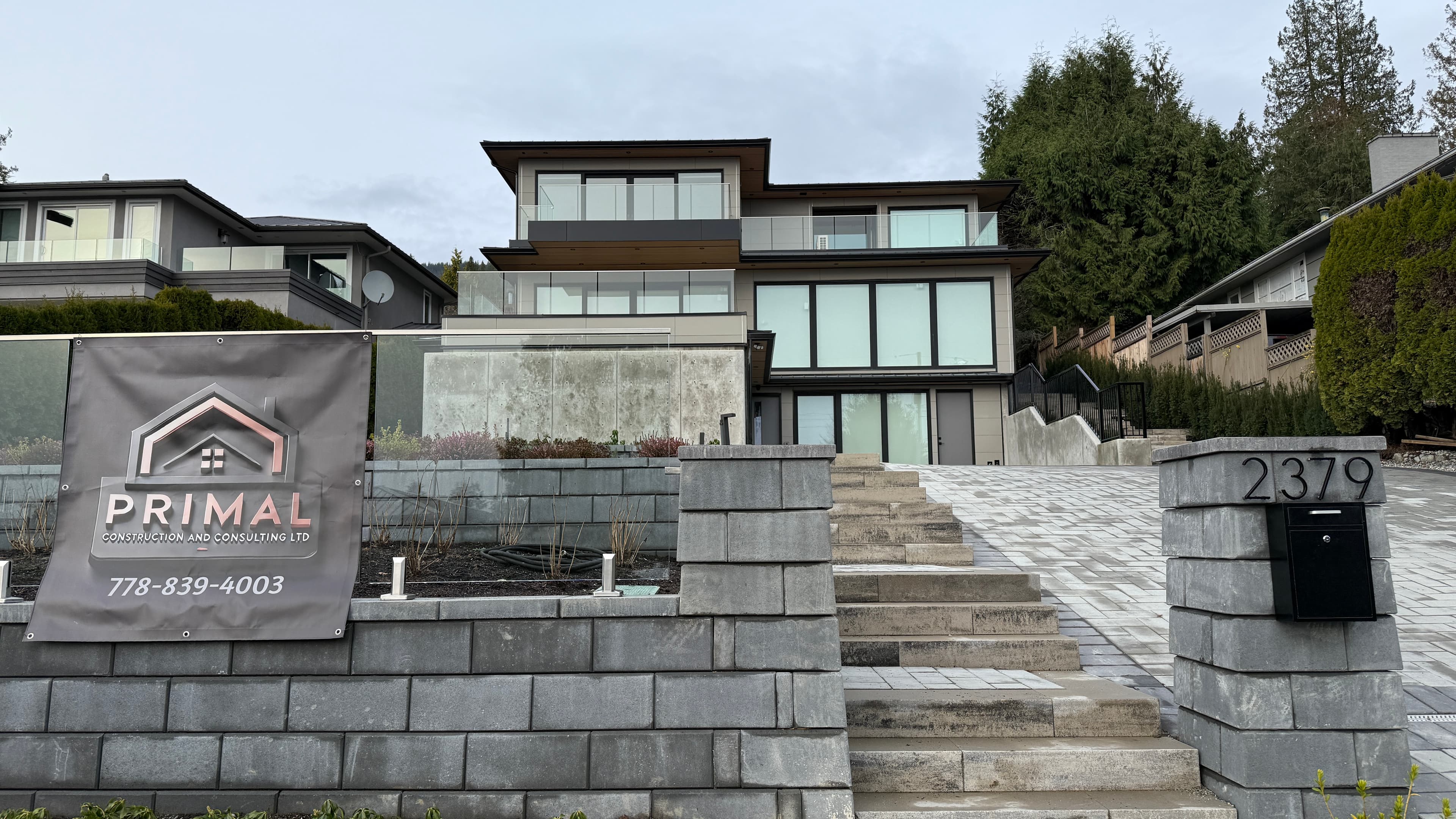 Nelson House 2 — front elevation on sloped lot with stone retaining walls